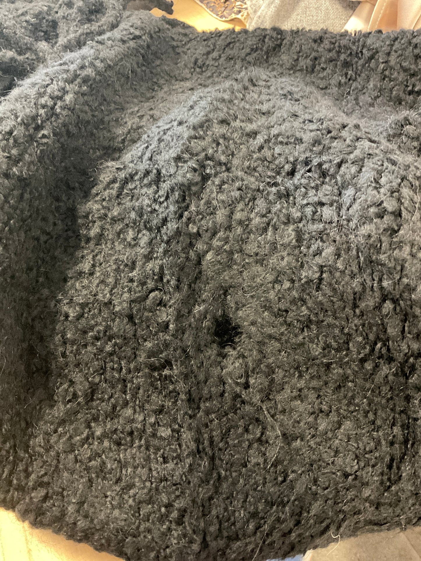 Defekte schwarze geknotete Weste