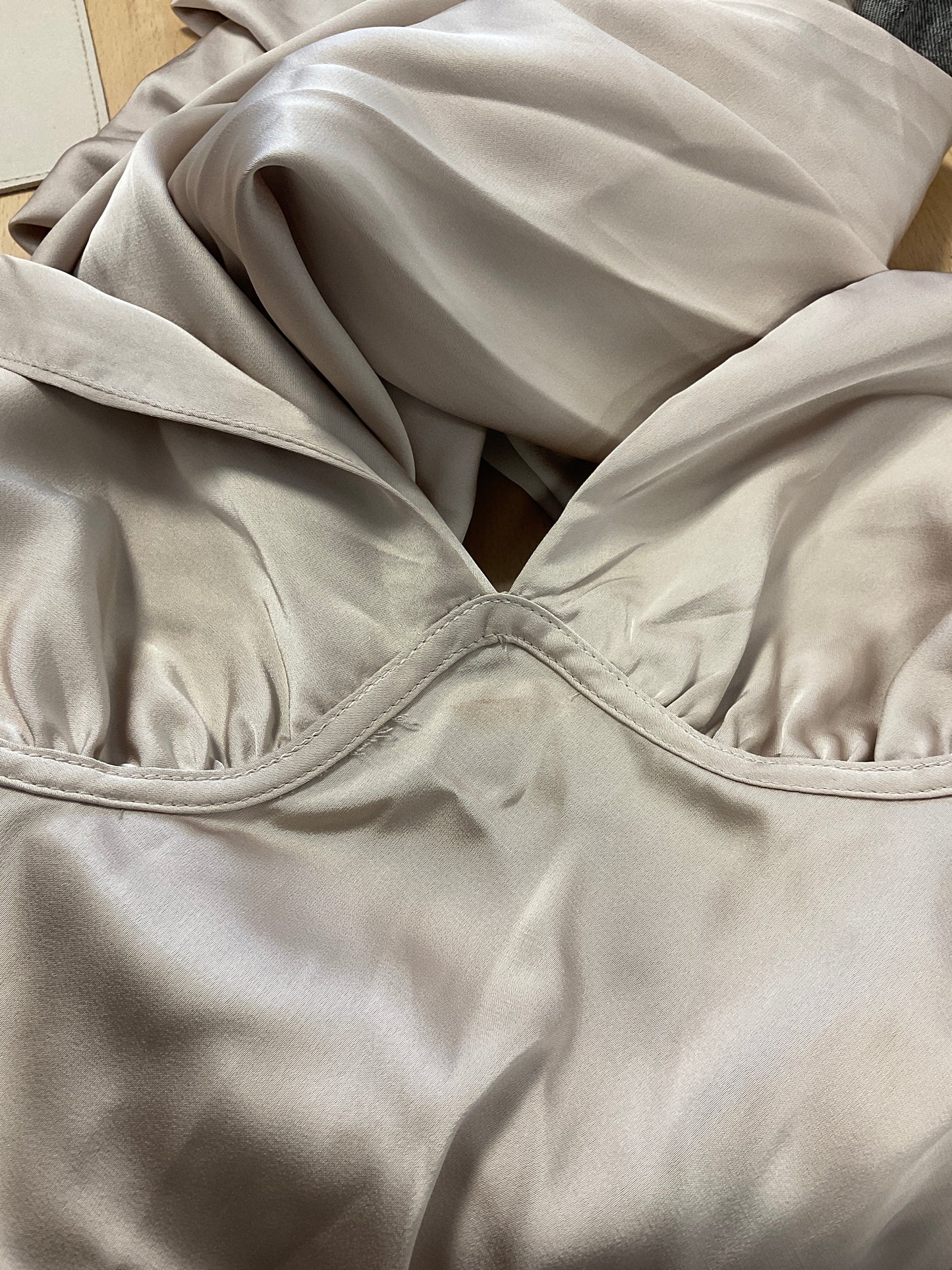 Mangelhaftes beigefarbenes Satinkleid