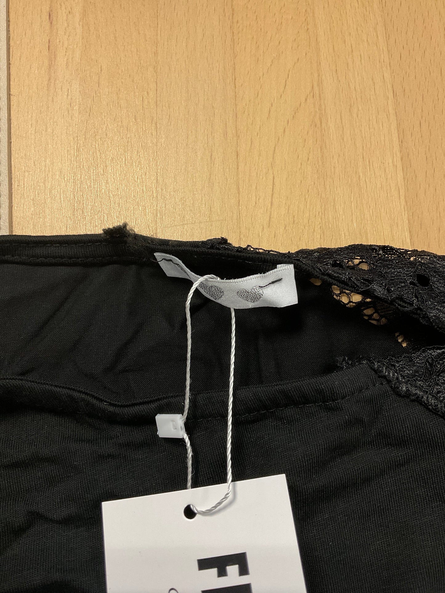 Defektes schwarzes asymmetrisches Spitzentop